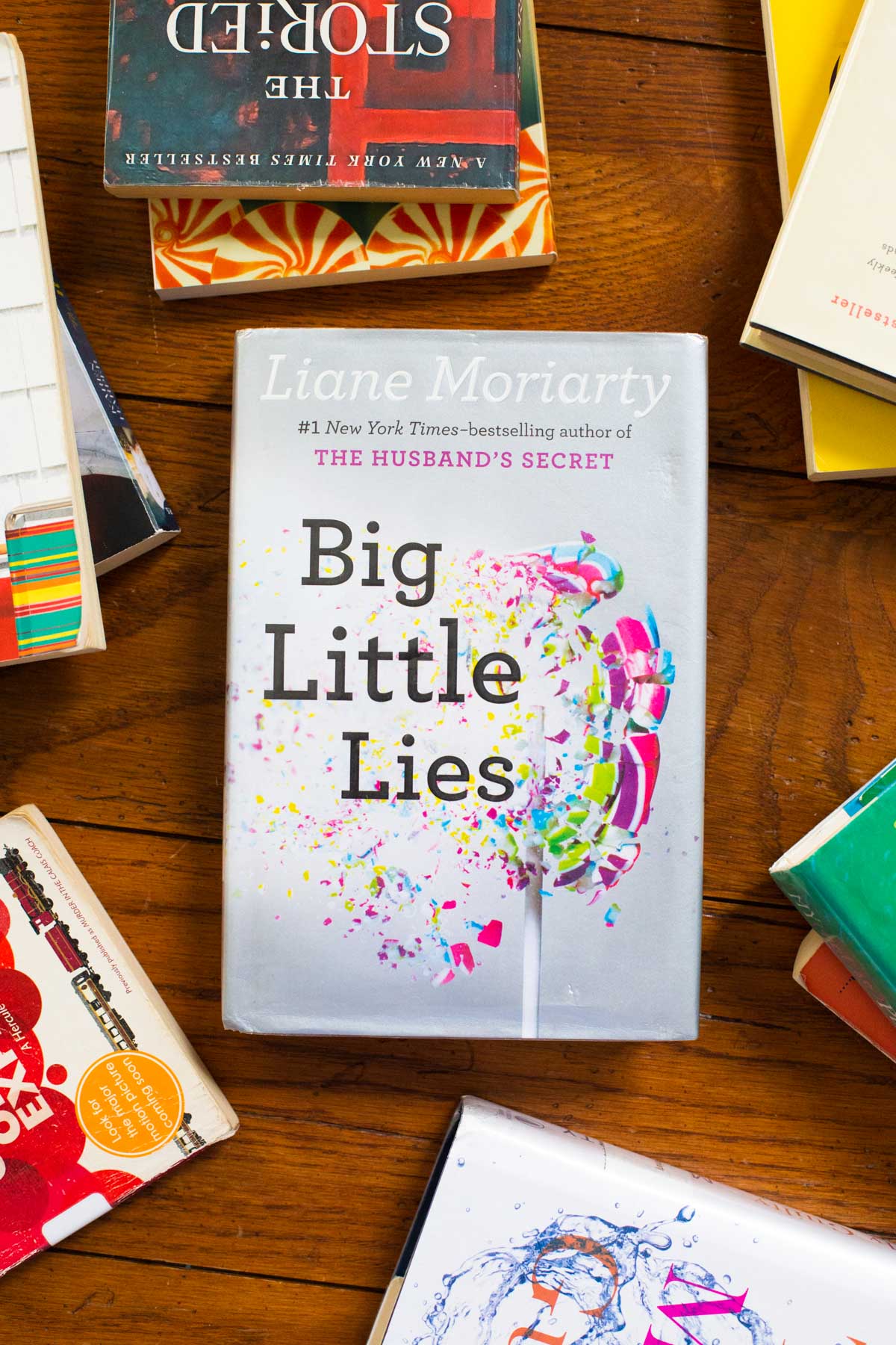 A copy of Big Little Lies is on a table surrounded by other books.