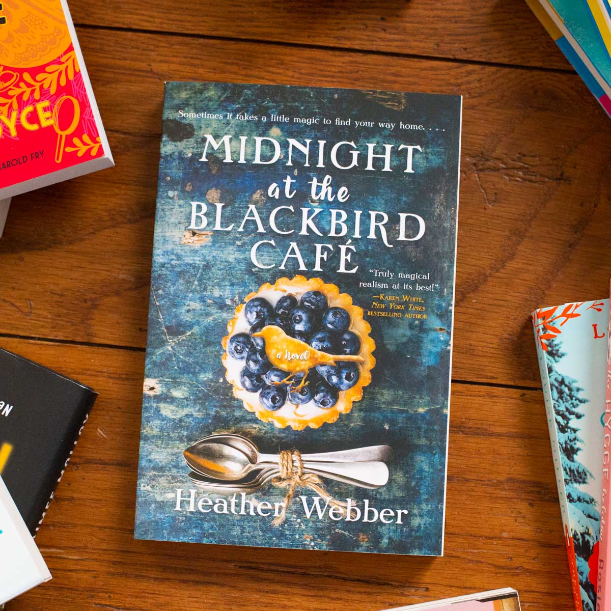 A copy of the book Midnight at the Blackbird Cafe is on the table.