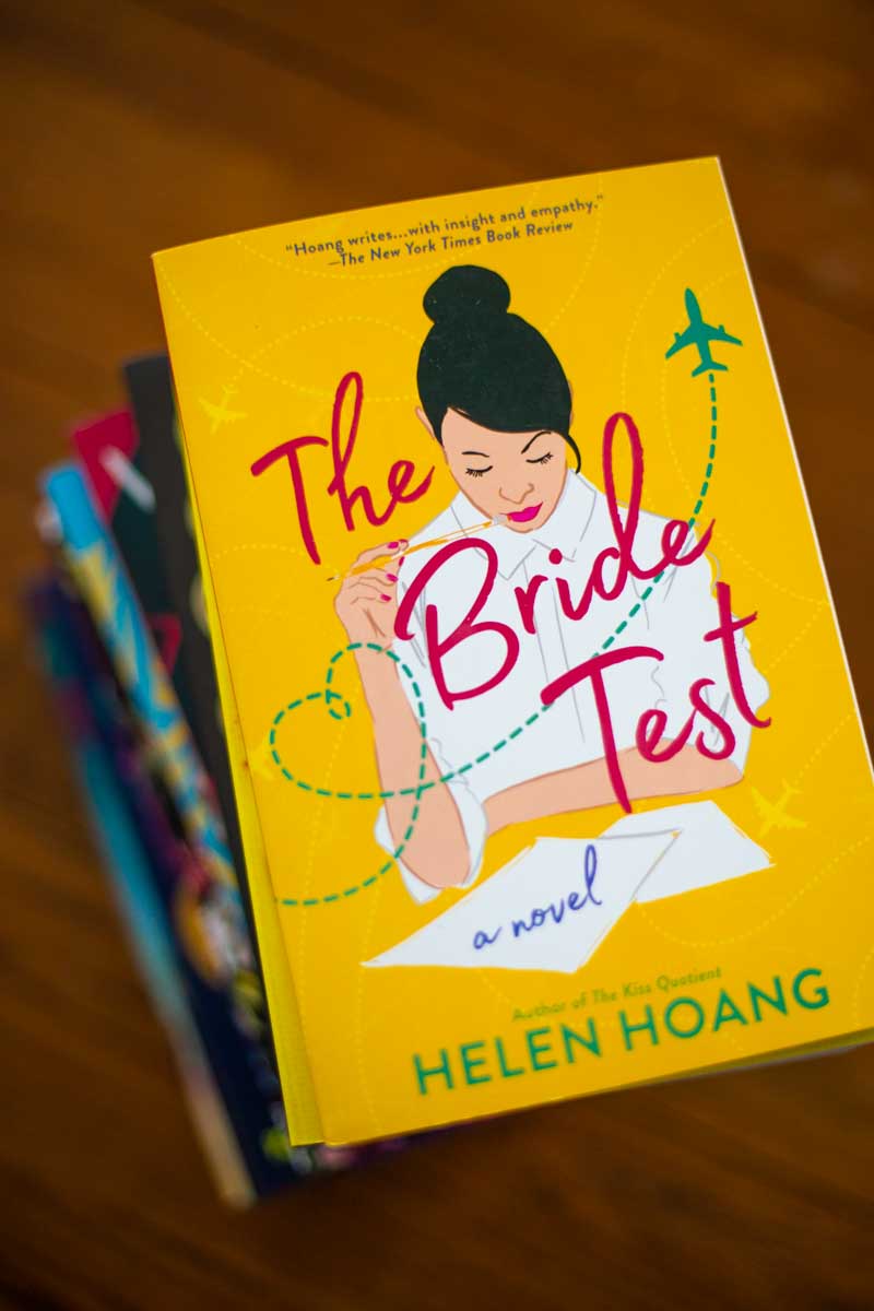 A copy of the book The Bride Test sits on a stack of books.