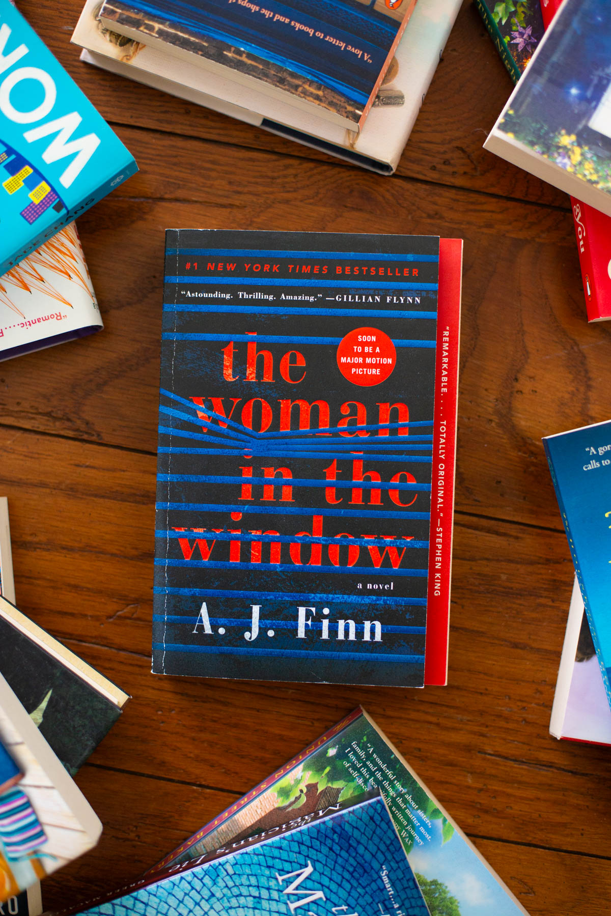 A copy of the book The Woman in the Window sits on a table.