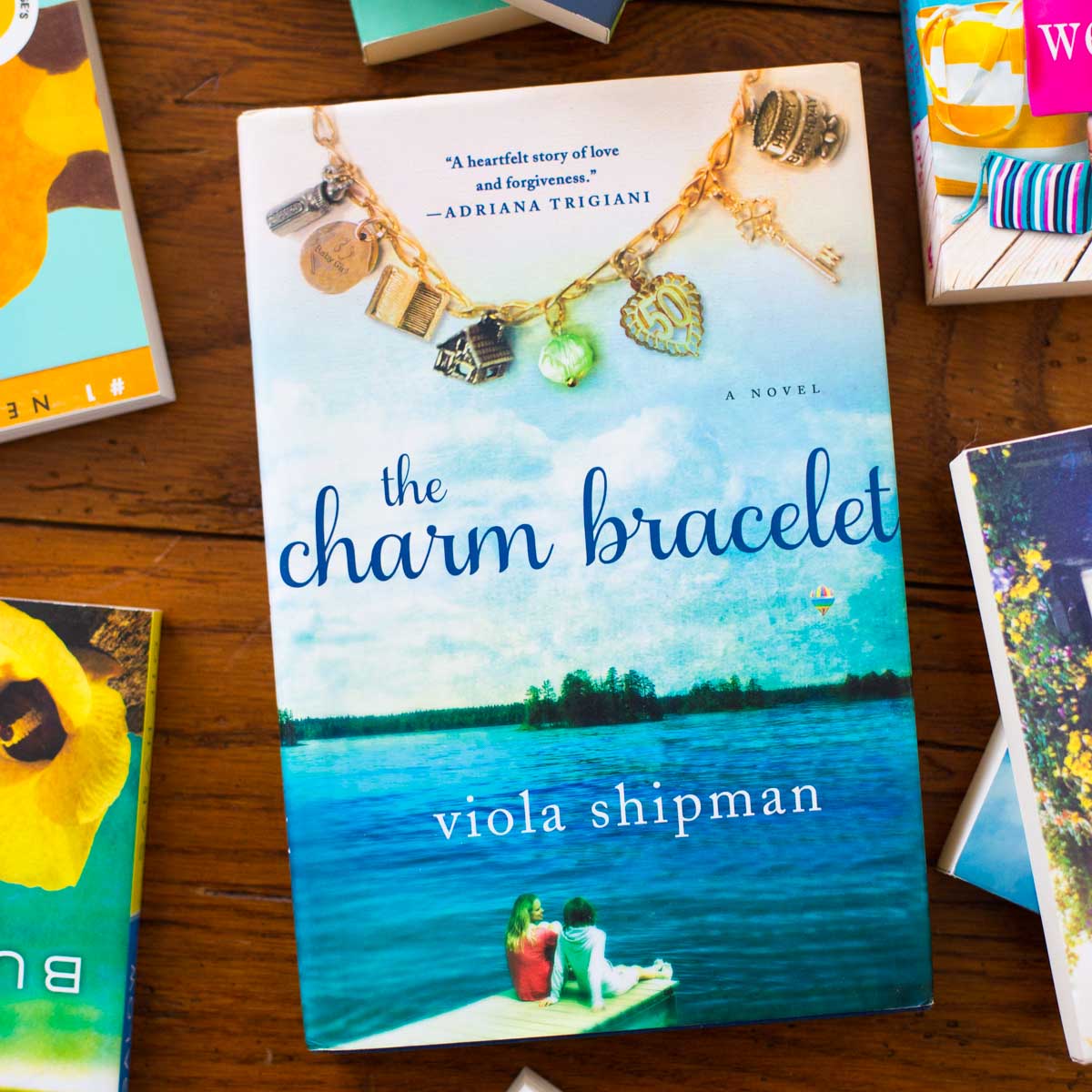 A copy of the book The Charm Bracelet is on the table.
