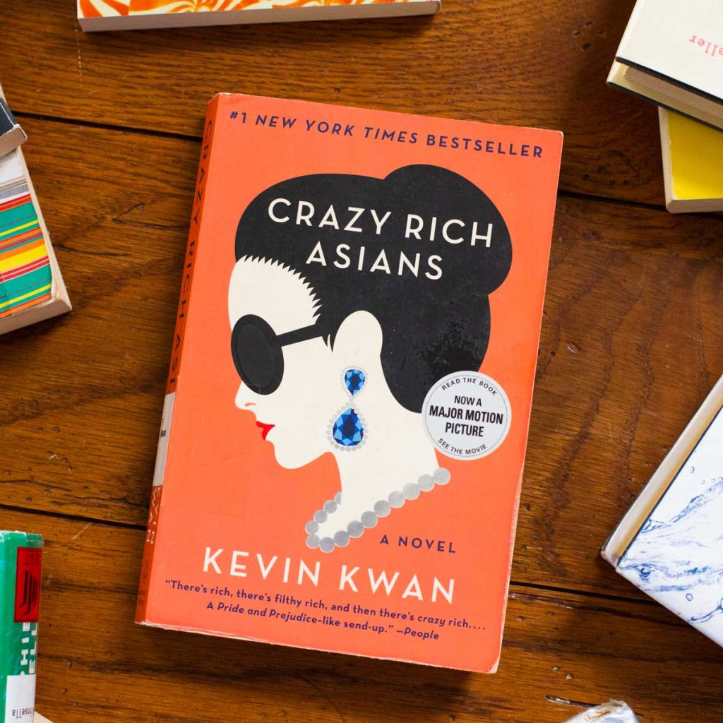 A copy of the book Crazy Rich Asians is on a table.