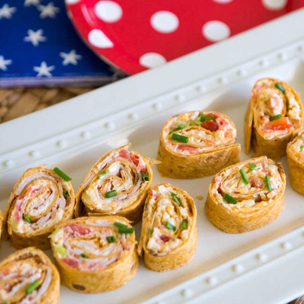 Spicy cream cheese pinwheels on a white platter.