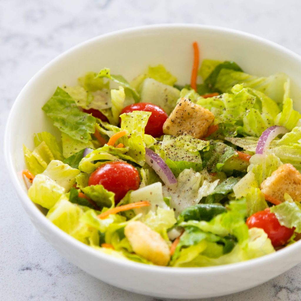 A fresh garden salad with lettuce, cherry tomatoes, and croutons.