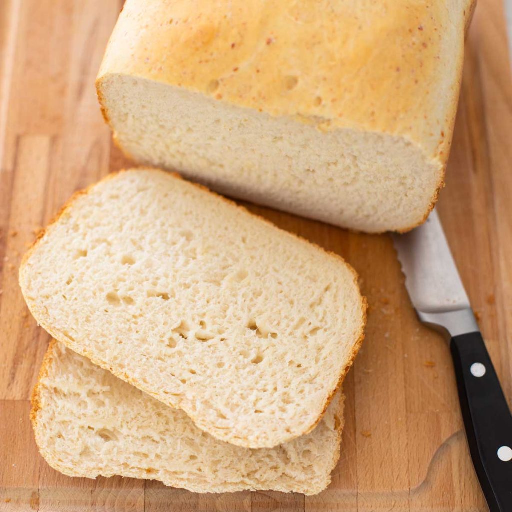 A loaf of homemade bread has been sliced with a knife.
