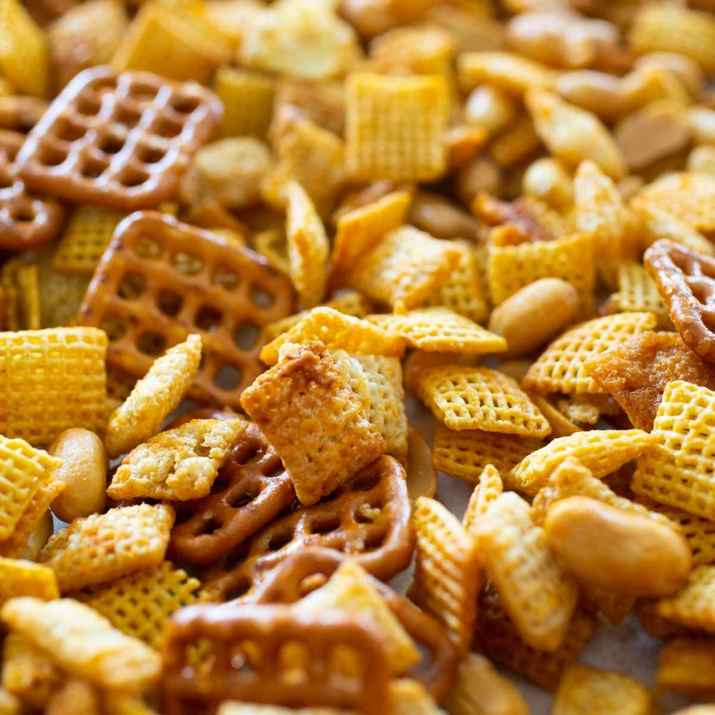 A close up of a spicy chex mix with pretzels and nuts.