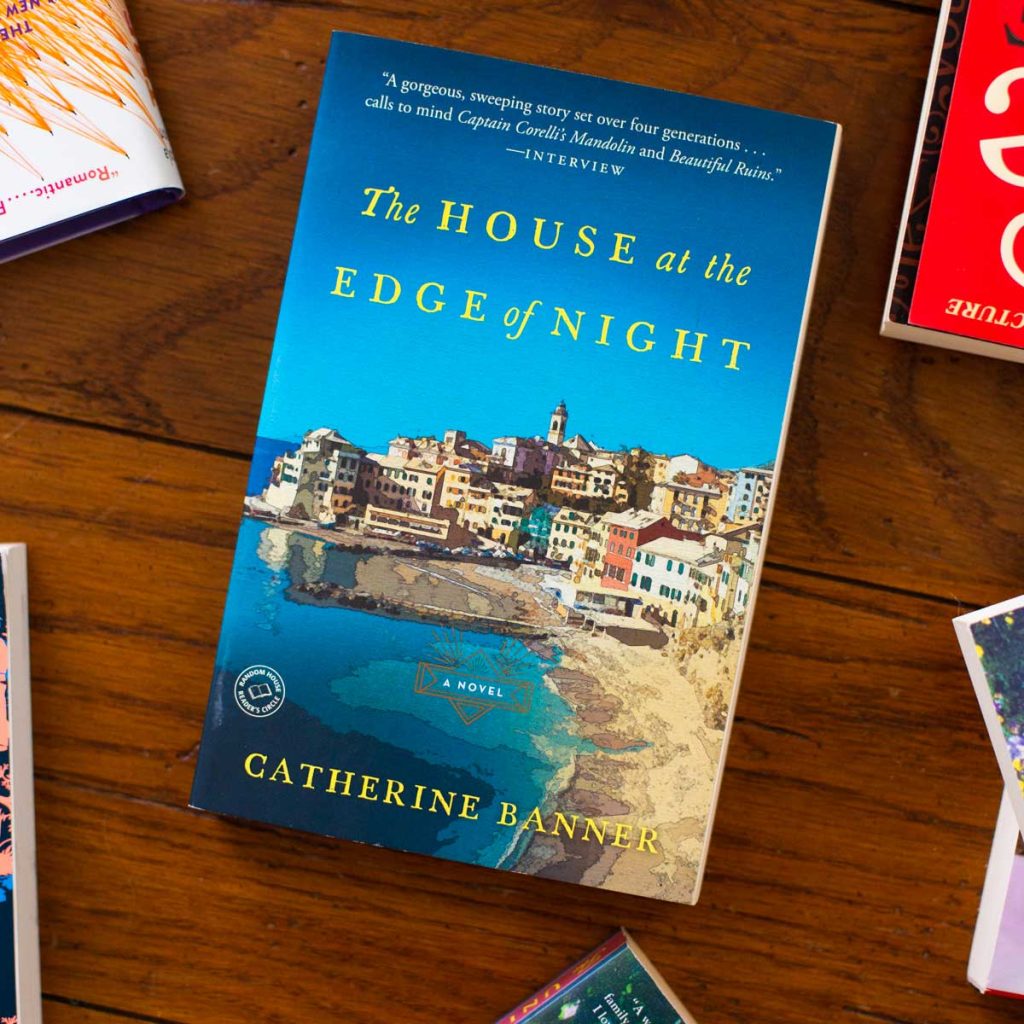 A copy of the book The House at the Edge of Night sits on a table.