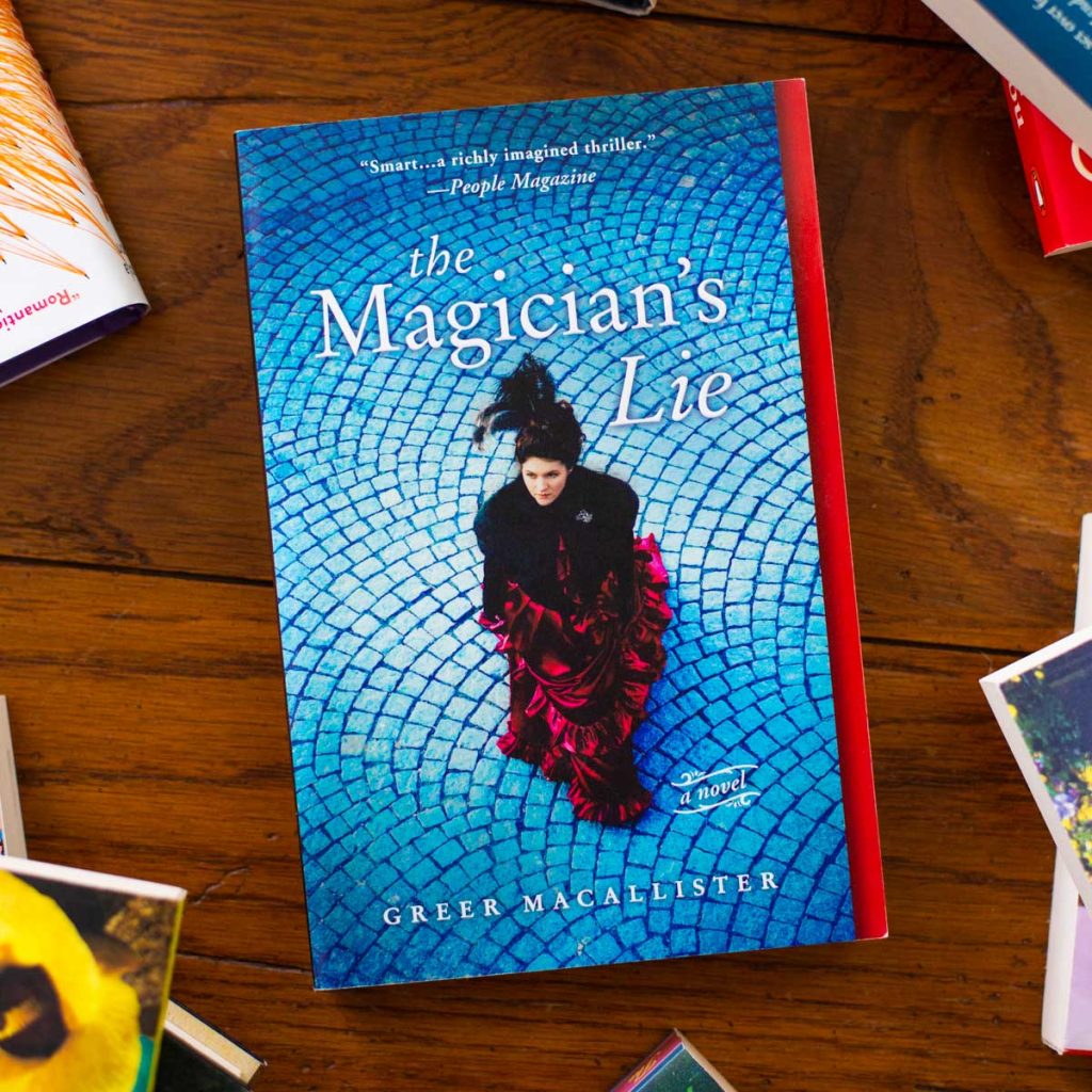 A copy of the book The Magician's Lie is on the table.