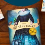 A copy of the book The Miniaturist is on the table.