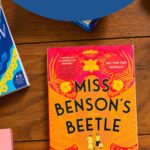 A copy of the book Miss Benson's Beetle is on the table.