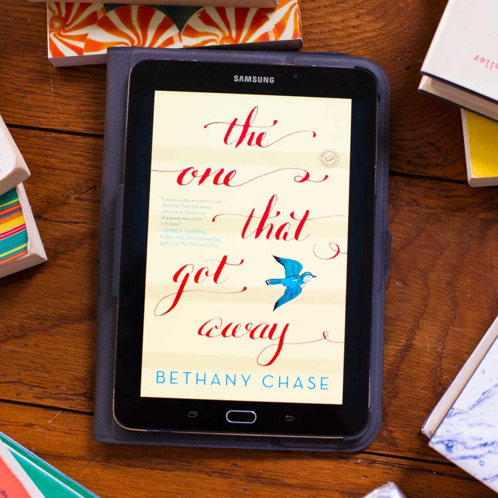 A digital reading tablet has the cover of the book The One That Got Away on the screen.