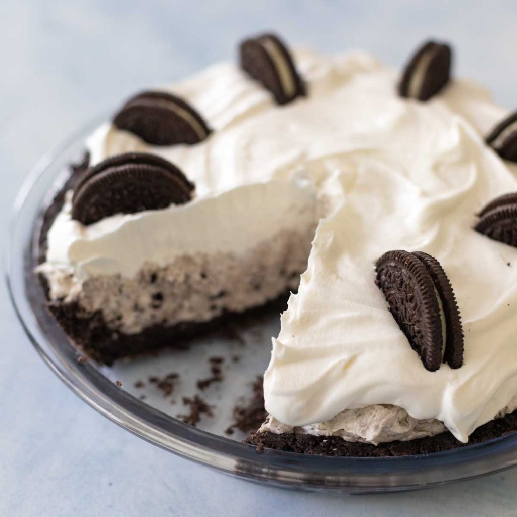 A creamy Oreo cookie pie has a slice missing from the pie plate.