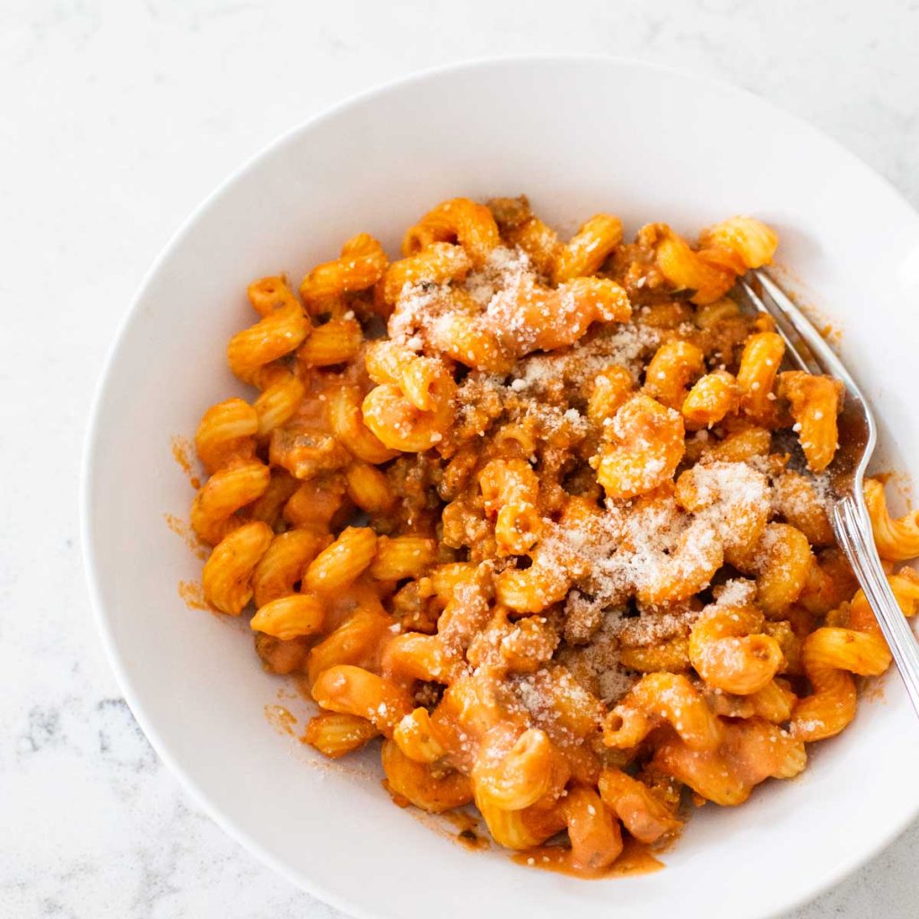 A corkscrew pasta is tossed in a creamy tomato sauce and sprinkled with parmesan cheese.