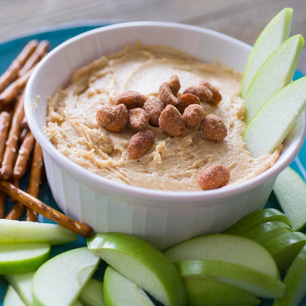 A fluffy peanut butter dip with fresh apple slices and pretzels.