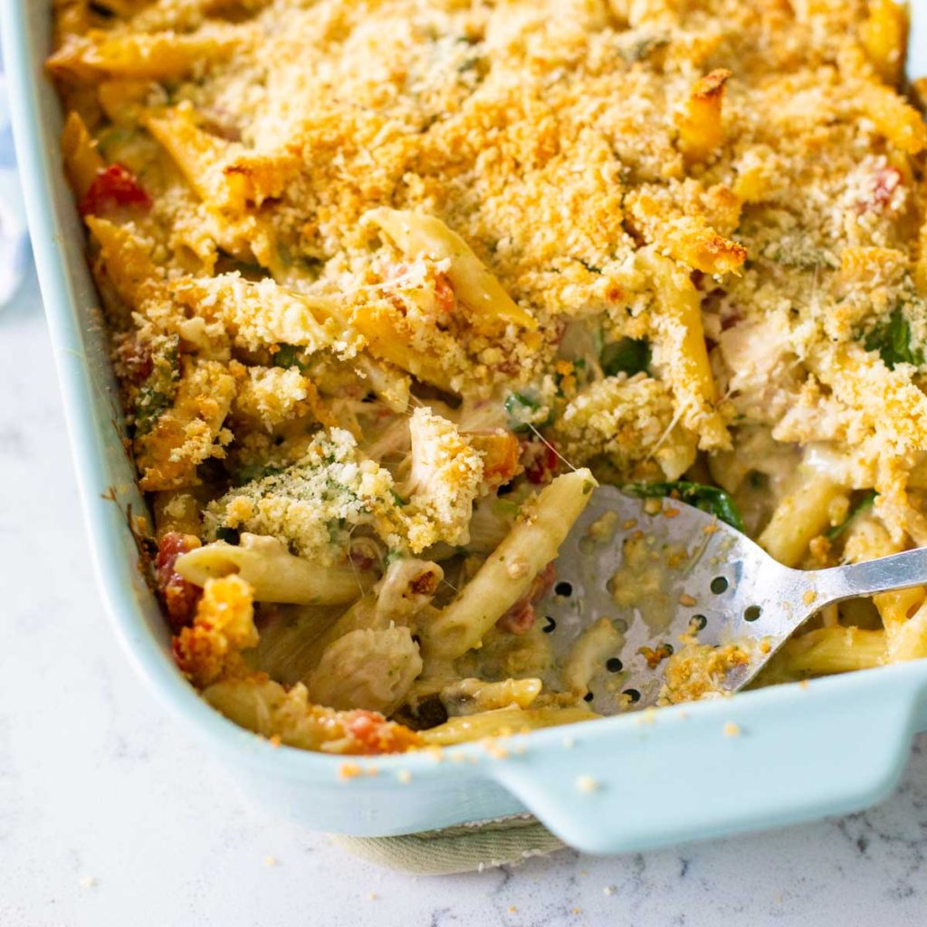 A baking dish is filled with a pasta casserole with breadcrumbs on top.