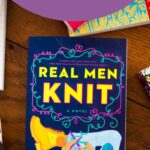 A copy of the book Real Men Knit is on the table.