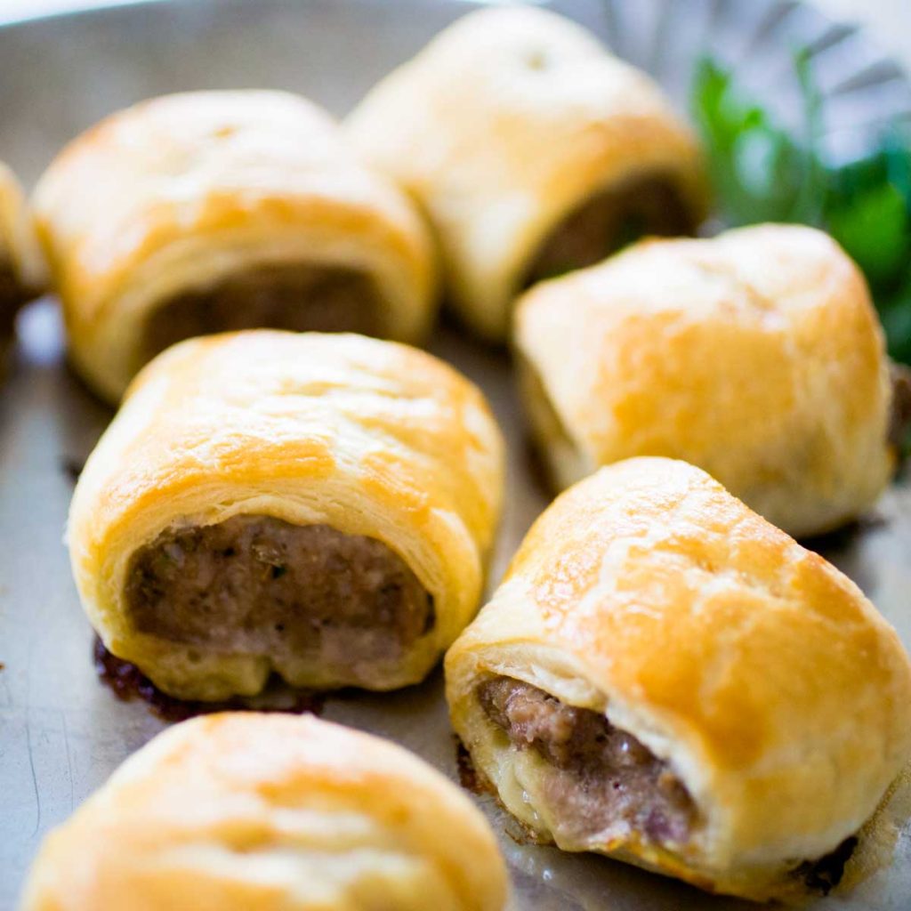 A platter of sausage rolls in puff pastry.