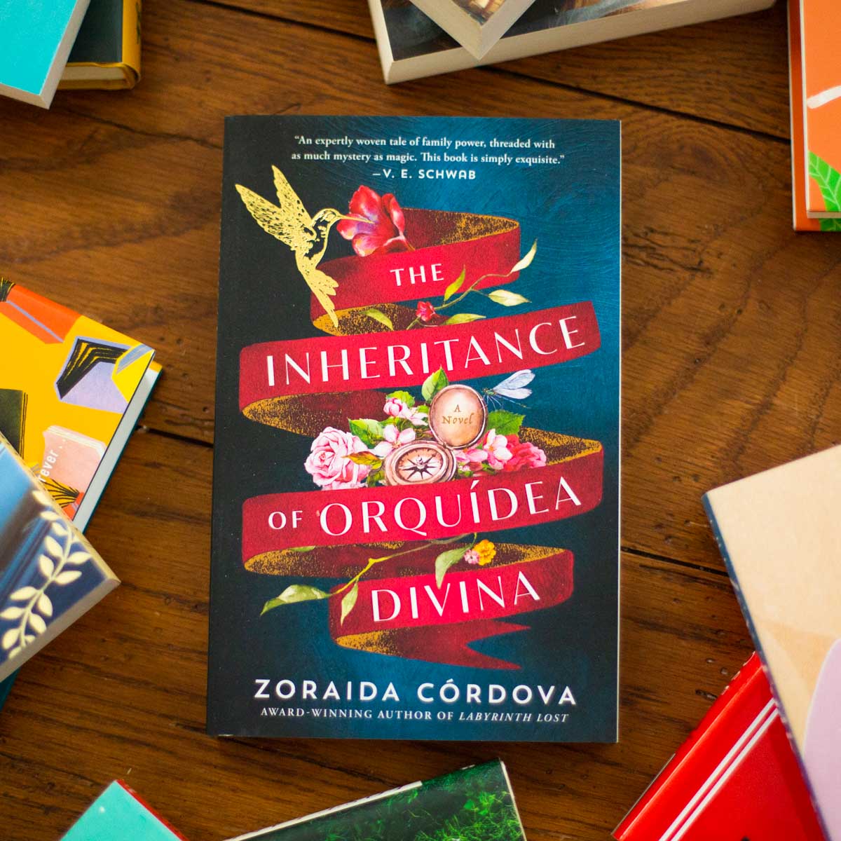 A copy of the book The Inheritance of Orquídea Divina by Zoraida Córdova sits on the table.