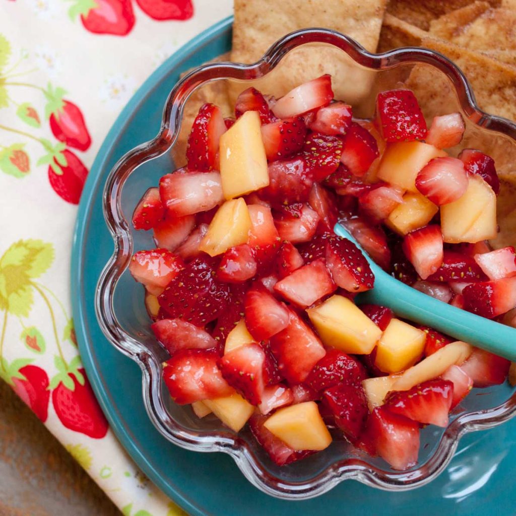 A bowl of strawberry salsa has diced mango mixed in.