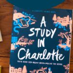 A copy of the book A Study in Charlotte sits on the table.