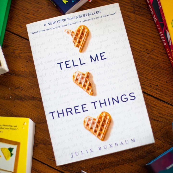 A copy of the book Tell Me Three Things is on the table.