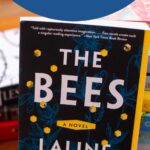 The copy of the book The Bees sits on a table.