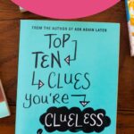 A copy of Top Ten Clues You're Clueless sits on a table.