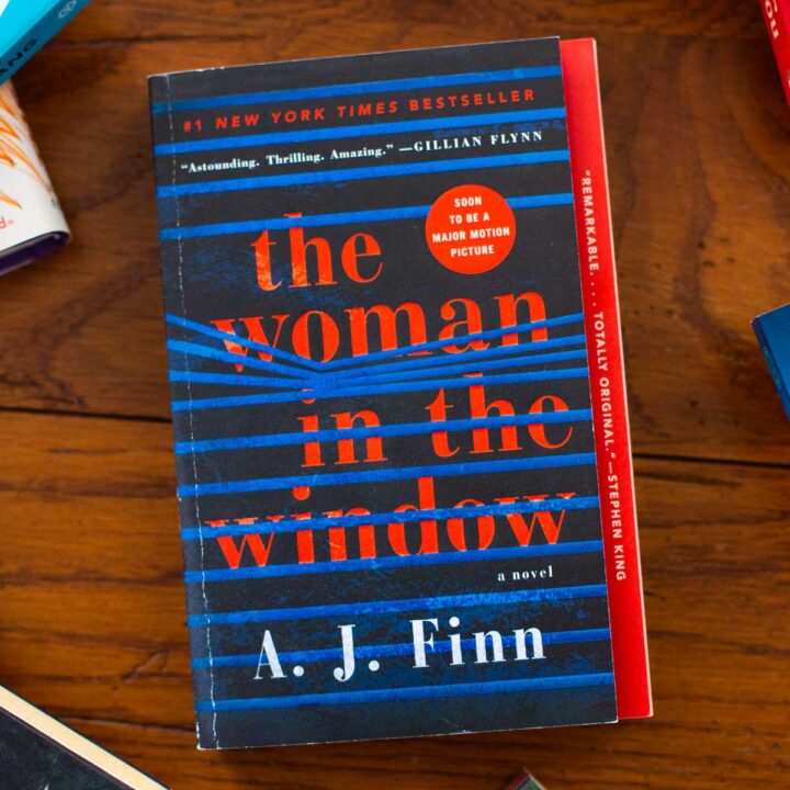 A copy of the book The Woman in the Window sits on a table.