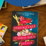 A copy of the book The Inheritance of Orquídea Divina by Zoraida Córdova sits on the table.