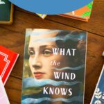 A copy of the book What the Wind Knows is on the table.