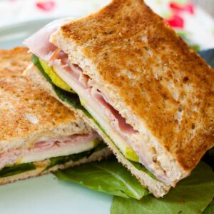 A grilled ham and havarti sandwich is on a plate.