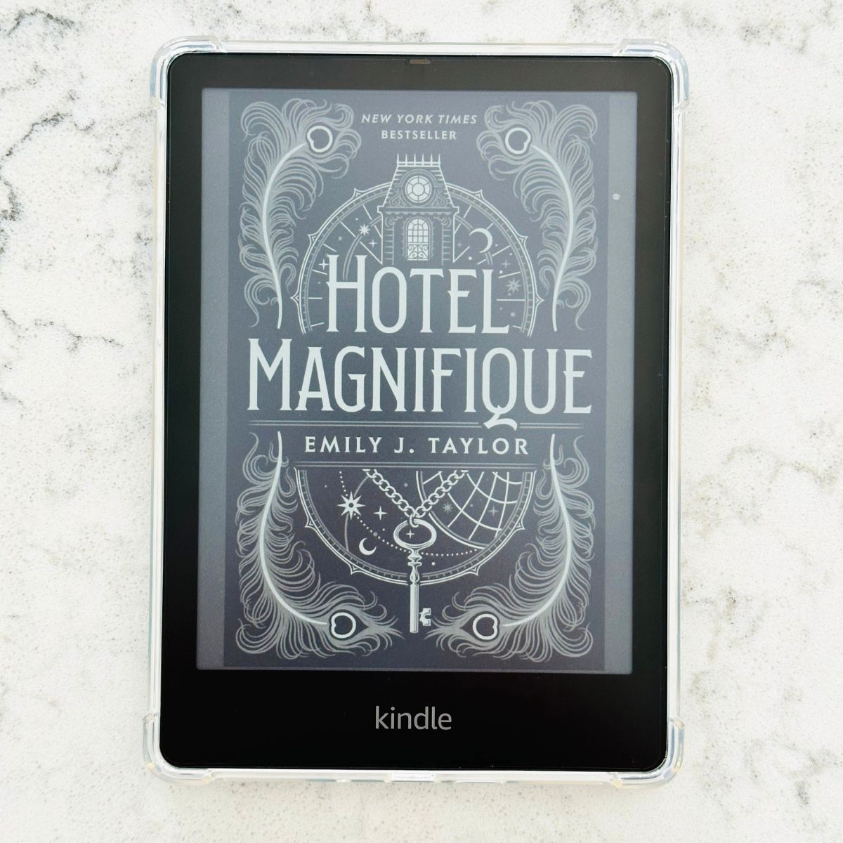 A Kindle Paperwhite has a clear plastic case in place and rests on the kitchen counter.