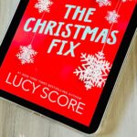 The cover of the book The Christmas Fix by Lucy Score is on the screen of an iPad.