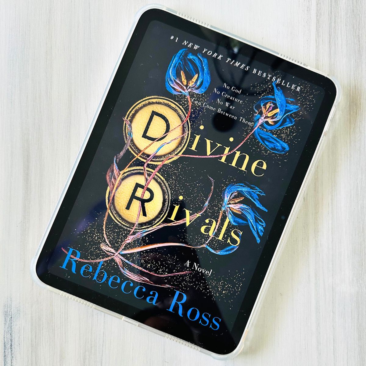 The cover of Divine Rivals appears on the screen of an iPad.