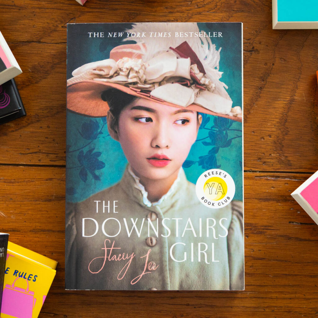 A copy of The Downstairs Girl sits on a table.