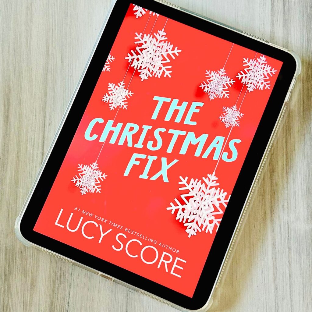 The cover of the book The Christmas Fix by Lucy Score is on an ipad screen.