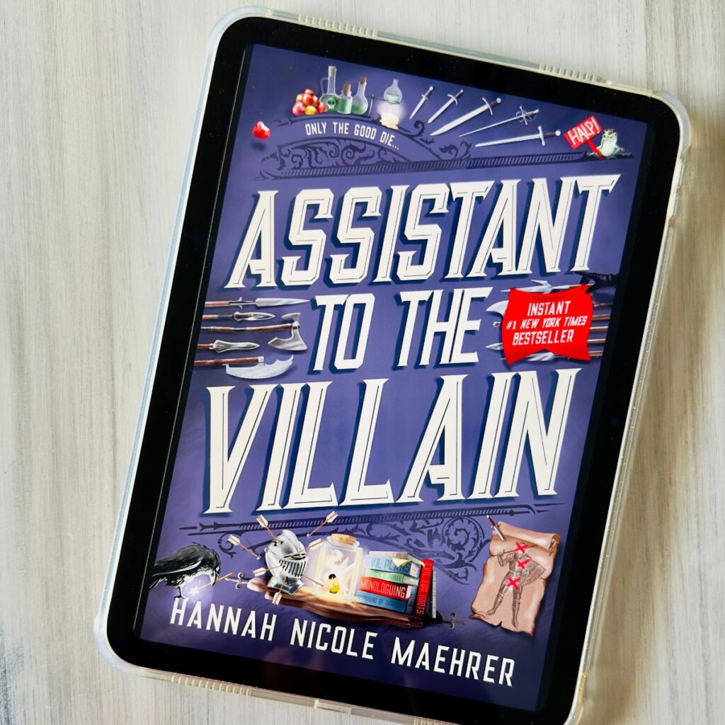 The cover of the book Assistant to the Villain by Hannah Nicole Maehrer is on the screen of an ipad.