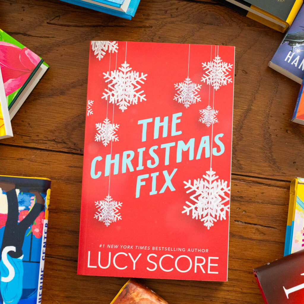 A copy of the book The Christmas Fix by Lucy Score sits on the table.