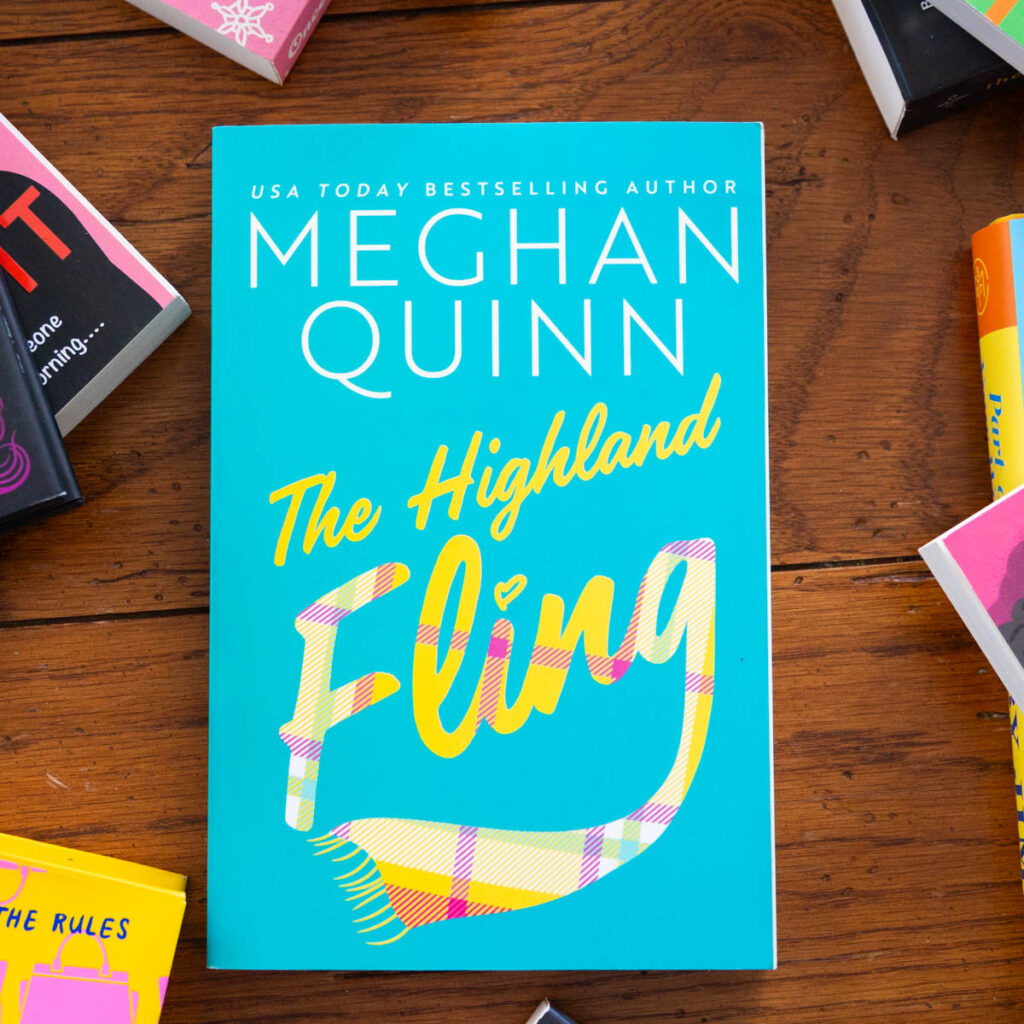 A copy of the book The Highland Fling by Meghan Quinn is on the table.