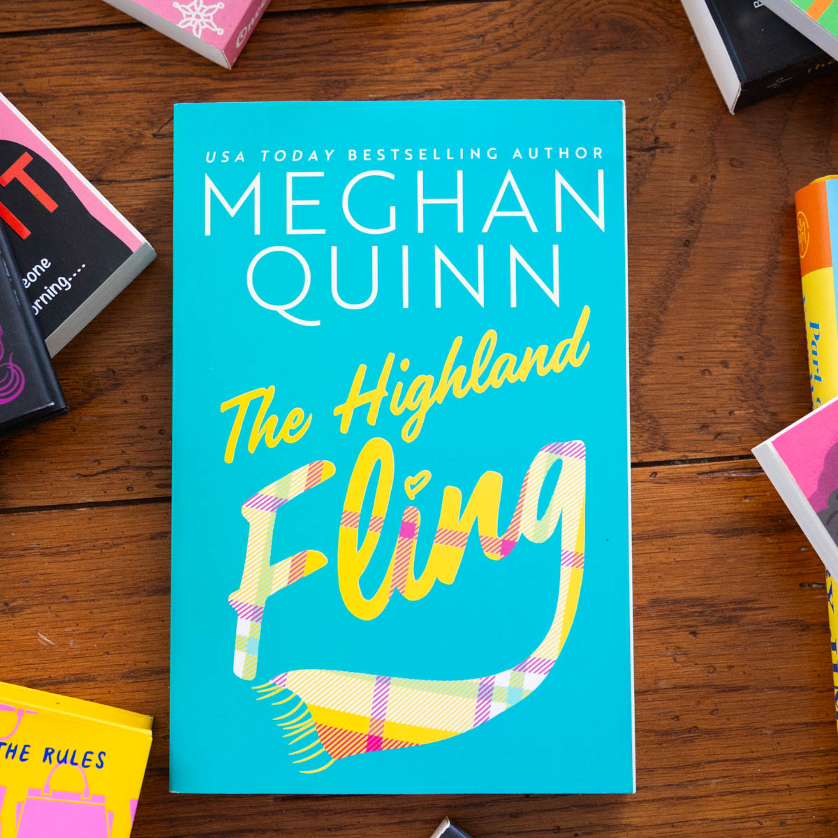 A copy of the book The Highland Fling by Meghan Quinn is on the table.