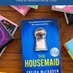 A copy of the book The Housemaid by Freida McFadden is on the table.