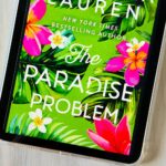 The cover of the book The Paradise Problem by Christina Lauren is on the screen of an Ipad.