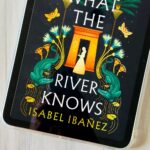 A copy of the book What the River Knows by Isabel Ibañez is on the screen of an iPad.