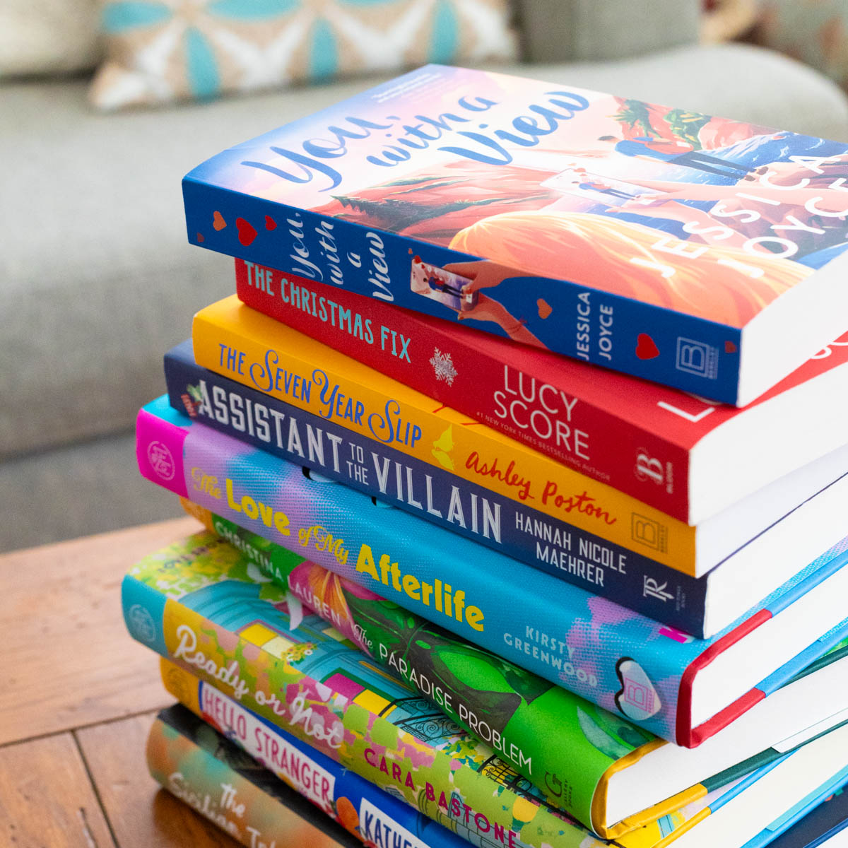 A stack of books sits on a coffee table next to the couch.