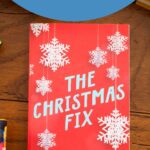A copy of the book The Christmas Fix by Lucy Score sits on the table.