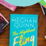 A copy of the book The Highland Fling by Meghan Quinn is on the table.