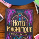 A copy of the book Hotel Magnifique is on the table.