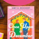 A copy of Once Upon a December by Amy E. Reichert sits on the table.