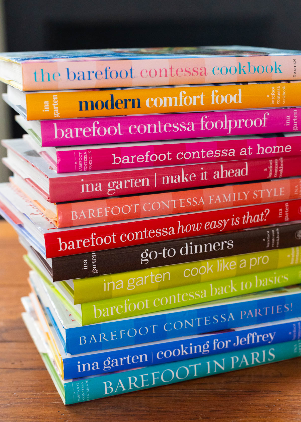 All of Ina Garten's Barefoot Contessa cookbooks are in a stack on the table.