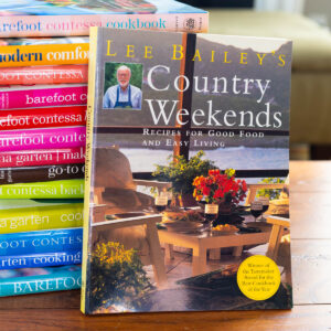 A copy of Lee Bailey's Country Weekends cookbook sits against a stack of Barefoot Contessa cookbooks.